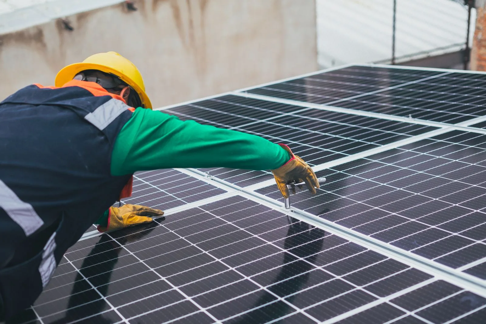 Técnico instalando paneles solares sobre el techo de una vivienda